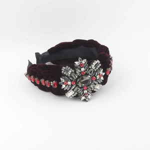 Detail of burgundy velvet braided headband with sparkling crystals and a grey oval gemstone