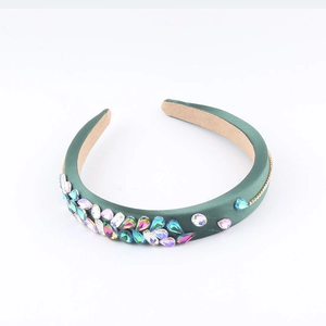 Cerchietto in raso verde scuro con strass colorati mostrato da un'angolazione di 45 gradi