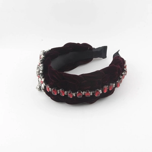 Detail of burgundy velvet braided headband with sparkling red rhinestones and silver floral crystal