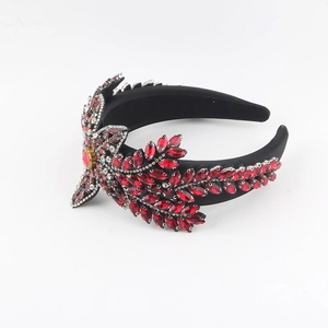 Détail d'un serre-tête de luxe avec feuilles de cristal rouge et motifs floraux strass