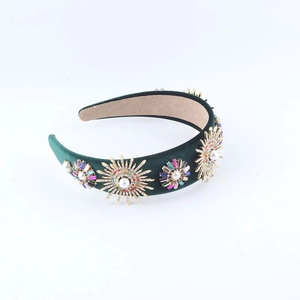 Detailansicht des dunkelgrünen Samt-Stirnbands mit goldenen Blumenmustern und Perlen