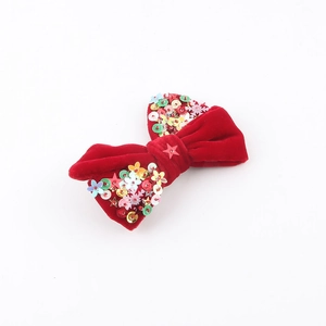 Vue détaillée du nœud en velours rouge de Noël avec paillettes en forme d'étoile et de flocon