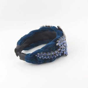 Detail of twisted blue velvet headband with navy rhinestones and pearl accents