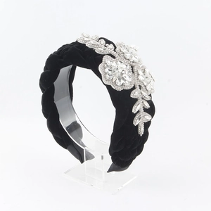 Detail view of woven black velvet headband with luxury crystal flower and leaf ornaments