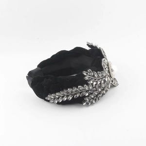 Detail of twisted black velvet headband with grey crystals and a central white pearl