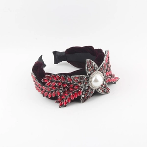 Detail of red velvet headband with rhinestones, crystals and a large pearl star