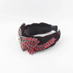 Detail view of burgundy velvet headband with braided twist and crystal flower pearl
