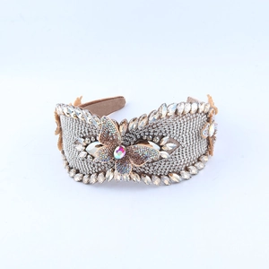 Détail d'un bandeau large de luxe orné de strass brillants et d'un papillon en 3D
