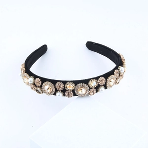 Detail of baroque headband with amber crystals and white pearls on black velvet fabric