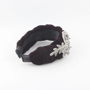 Close-up of velvet braided headband with sparkling rhinestone flower embellishments