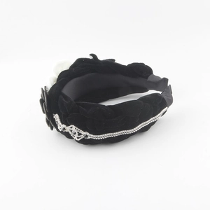 Detailed close-up of velvet headband featuring braided texture and rhinestone trim