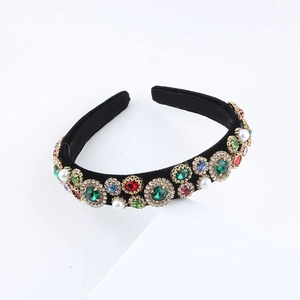 Close-up of Baroque velvet headband with colorful emerald and ruby gemstones