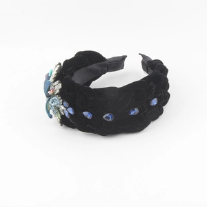 Detail of black velvet braided headband with blue crystals and insect jewelry piece