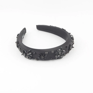 Macro detail of handmade beaded flowers and black sequins on padded headband