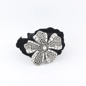 Luxury black velvet braided headband featuring a large sparkling crystal flower ornament