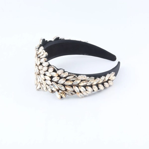 Detail of a wide black velvet headband featuring champagne marquise crystal leaf patterns