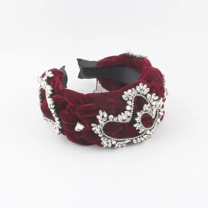 Close-up of velvet braided headband in burgundy with sparkling heart-shaped crystals
