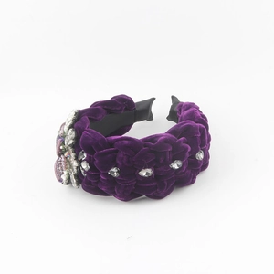 Detail of dark purple velvet braided headband with sparkling rhinestone flower embellishments