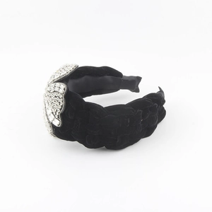 Detail of black velvet braided headband with sparkling large rhinestones decoration