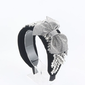 Detail of luxury black velvet headband with a large rhinestone bow and leaf cluster