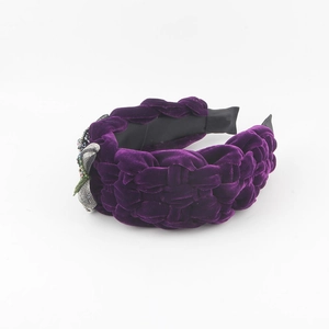 Macro detail of purple velvet braided headband with intricate floral beadwork embroidery
