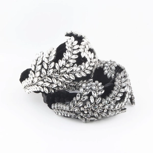 Detail of baroque rhinestone headband with sparkling leaf pattern on black velvet fabric