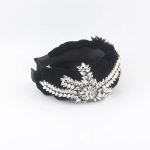 Detailed macro of rhinestone leaf patterns on braided black velvet headband