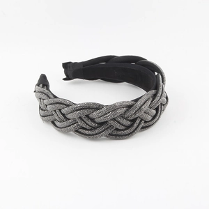 Detailed view of the woven braid texture with silver rhinestones on this wide black headband