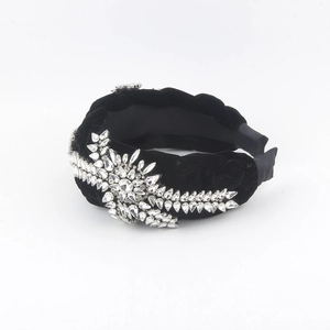 Detail of black velvet braided headband featuring sparkling crystal leaf embellishments
