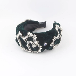 Detail view of dark green velvet braided headband with sparkling rhinestone heart accents