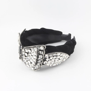 Détail du serre-tête en velours noir orné de motifs d'ailes en strass brillants