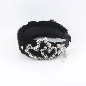 Detail view of black velvet headband with double heart rhinestones and tassel fringe