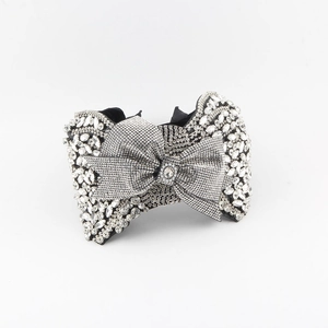 Macro detail of luxury bow headband featuring sparkling rhinestones and crystal clusters