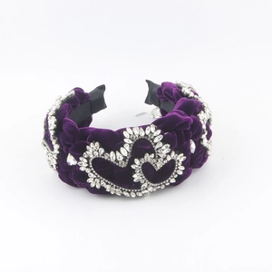 Macro detail of purple velvet braided headband with sparkling rhinestone heart patterns