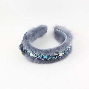 Detail of grey faux fur headband featuring luxury rhinestones and blue floral embellishments