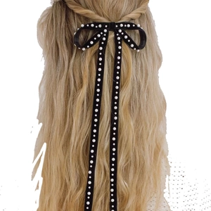 Detail of elegant black velvet bow hair clip with hanging pearls and long tassels
