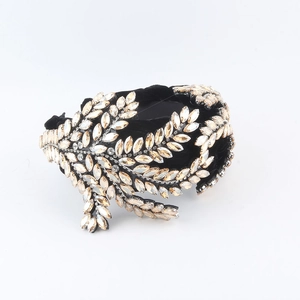 Detailed macro view of luxury baroque headband with gold marquise rhinestones and black velvet