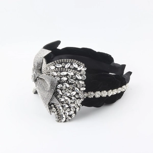 Close-up of black velvet headband with luxury rhinestone bow and woven crystal details