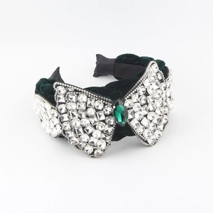 Détail du serre-tête en velours avec cristal émeraude vert et strass brillants