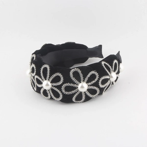 Detail of velvet headband featuring pearl center flowers and rhinestone petal borders