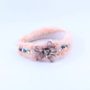 Detail eines rosa Kunstpelz Stirnbands mit handgefertigter lila Stoffblume und bunten Perlen