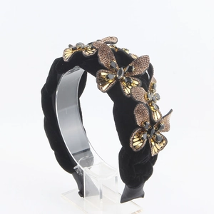 Detail of black velvet braided headband featuring golden butterflies with rhinestones