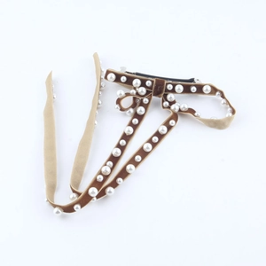 Detail of brown velvet bow hair clip with white faux pearls and black metal duckbill clip