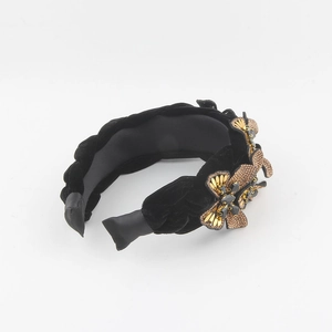 Detail of black velvet headband with gold butterfly metal base and crystals