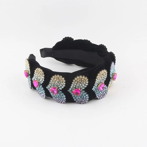 Close-up of colorful rhinestone heart embellishments on a black velvet padded headband