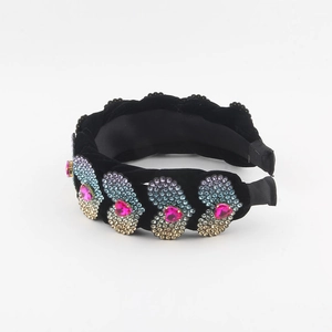 Close-up of heart rhinestones on black velvet padded headband with crystal details