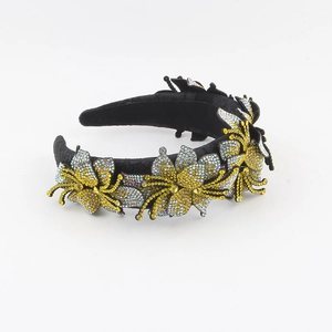 Dettaglio del cerchietto in velluto nero con decorazioni floreali in strass luccicanti