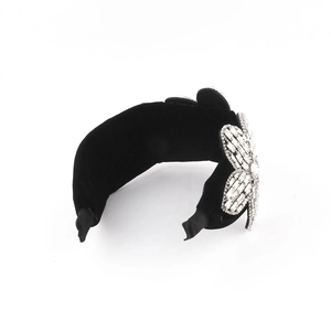 Close-up of black velvet padded headband featuring a large crystal floral side embellishment