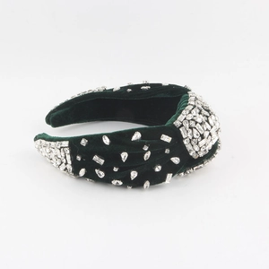 Close-up of dark green velvet headband with hand-sewn silver rhinestones in twisted design