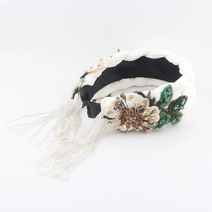 Detail of velvet braided headband featuring floral embroidery and crystal tassel fringe